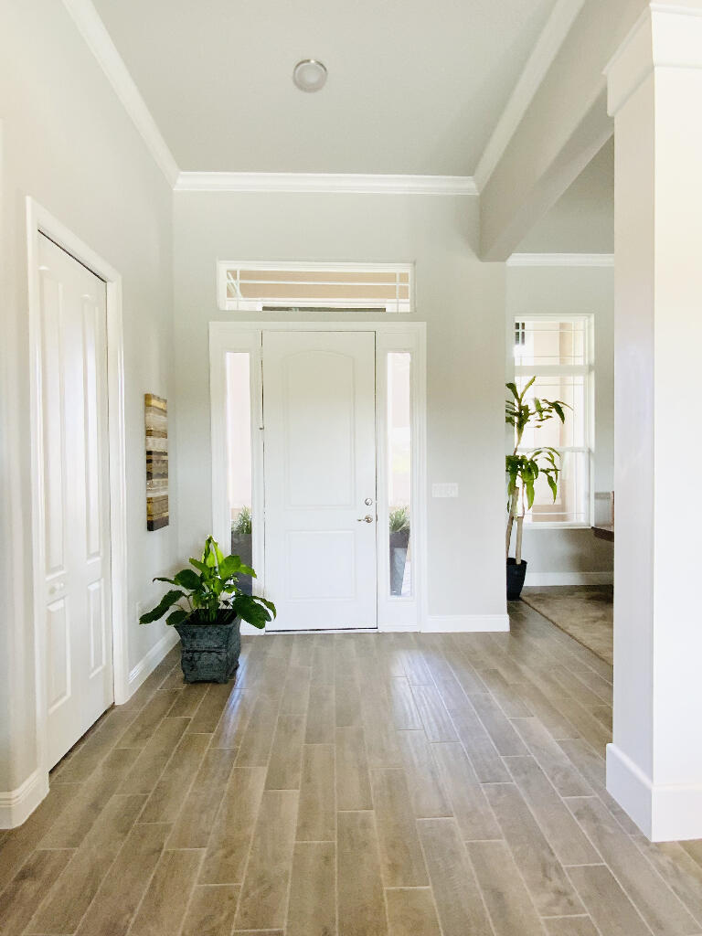 4644 Capri Lane Melbourne, FL 32935 - Photo 4 of 43 a view of a hallway with wooden floor and a dining room