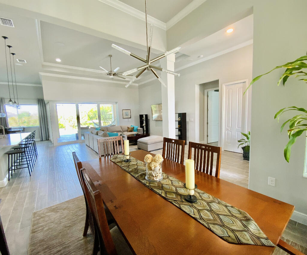 4644 Capri Lane Melbourne, FL 32935 - Photo 8 of 43 a dining room with furniture a chandelier and wooden floor
