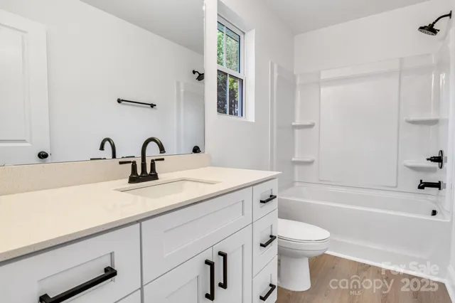 a bathroom with a double vanity sink toilet and shower