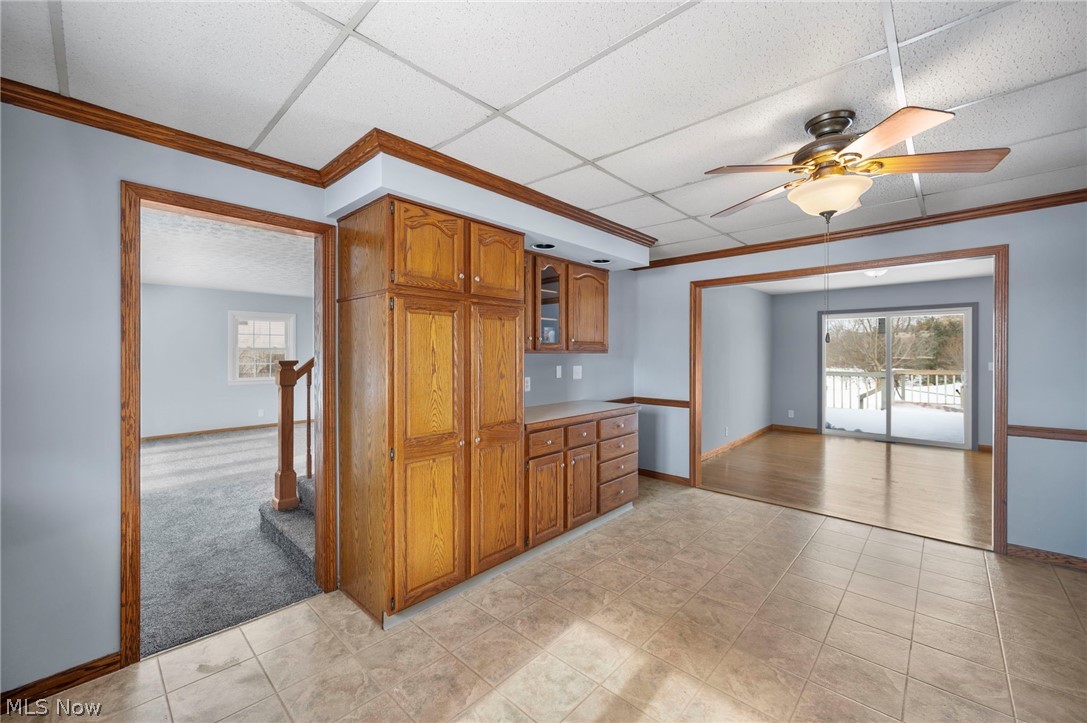 2099 Pontius Road Mogadore, OH 44260 - Photo 11 of 35 Kitchen with wood finish cabinets, a ceiling fan, light countertops, ornamental molding, and a drop ceiling