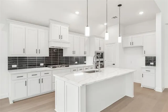 a kitchen with white cabinets sink and stainless steel appliances