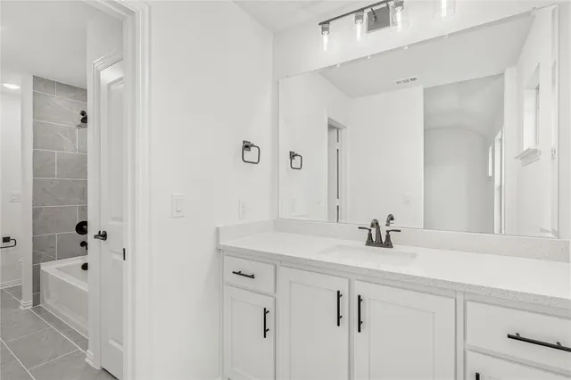a bathroom with a double vanity sink and mirror with bathtub