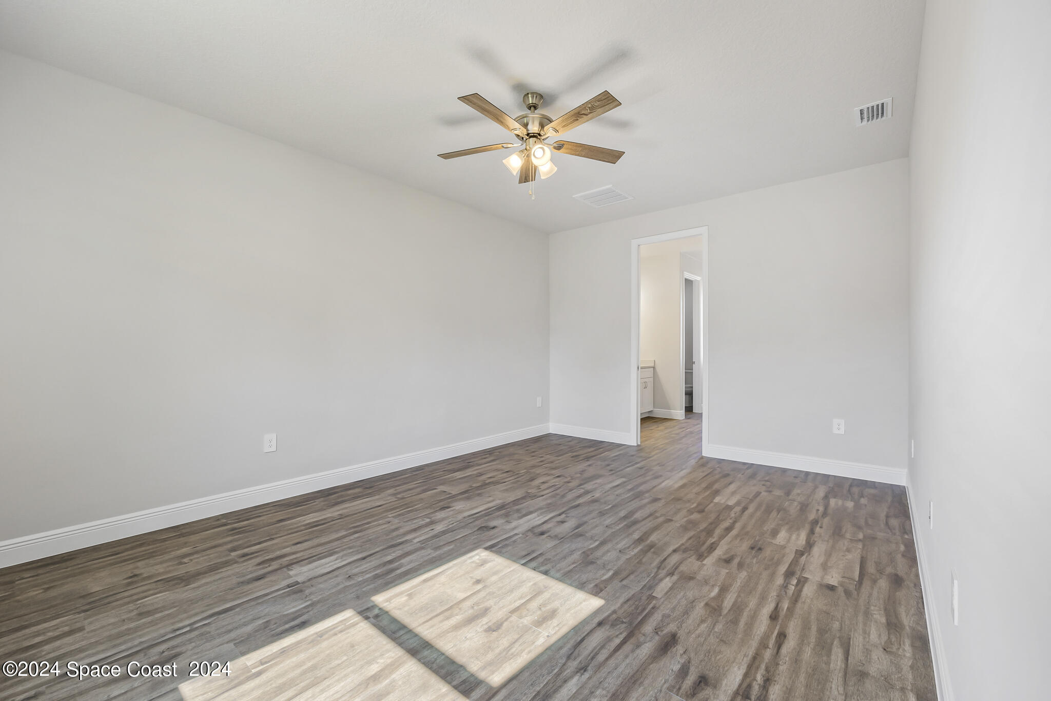 1368 Rabbit Street Southeast Palm Bay, FL 32909 - Photo 17 of 31 an empty room with wooden floor and a ceiling fan