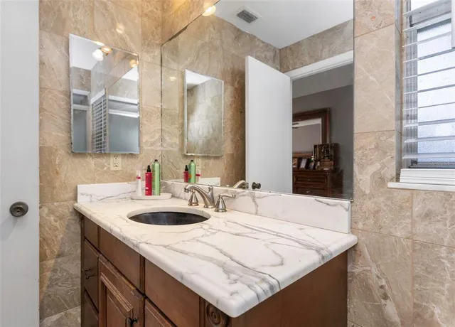 a kitchen with stainless steel appliances granite countertop white cabinets and a window