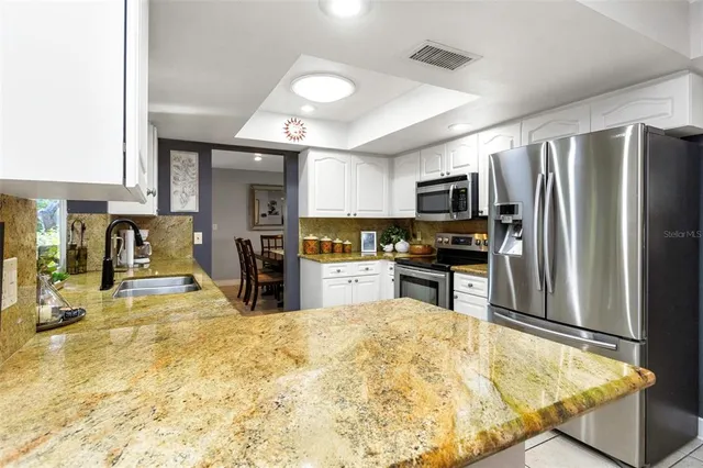 a living room with furniture and a dining table with wooden floor