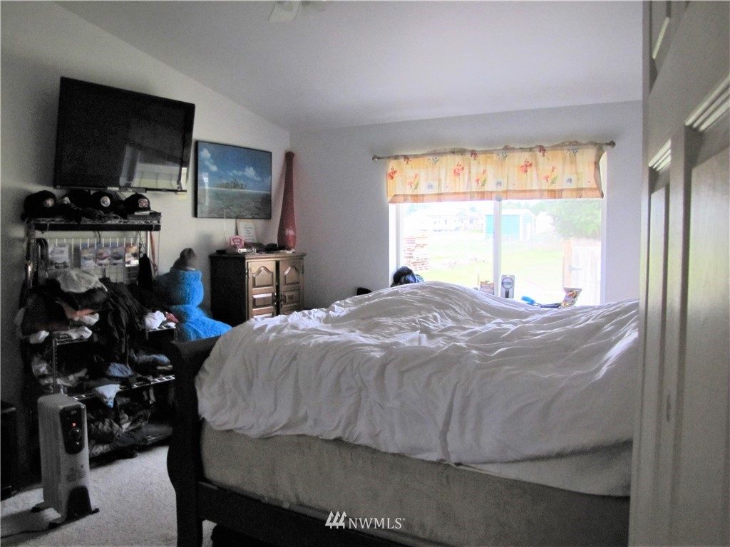 11 Stone Road Sequim, WA 98382 - Photo 17 of 21 a bedroom with a bed and a flat tv screen