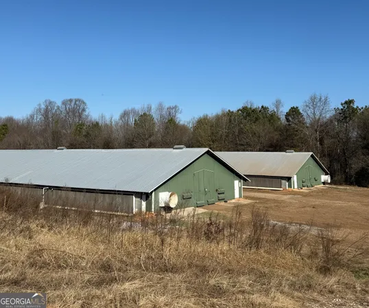 a view of house with a yard and trees in the background