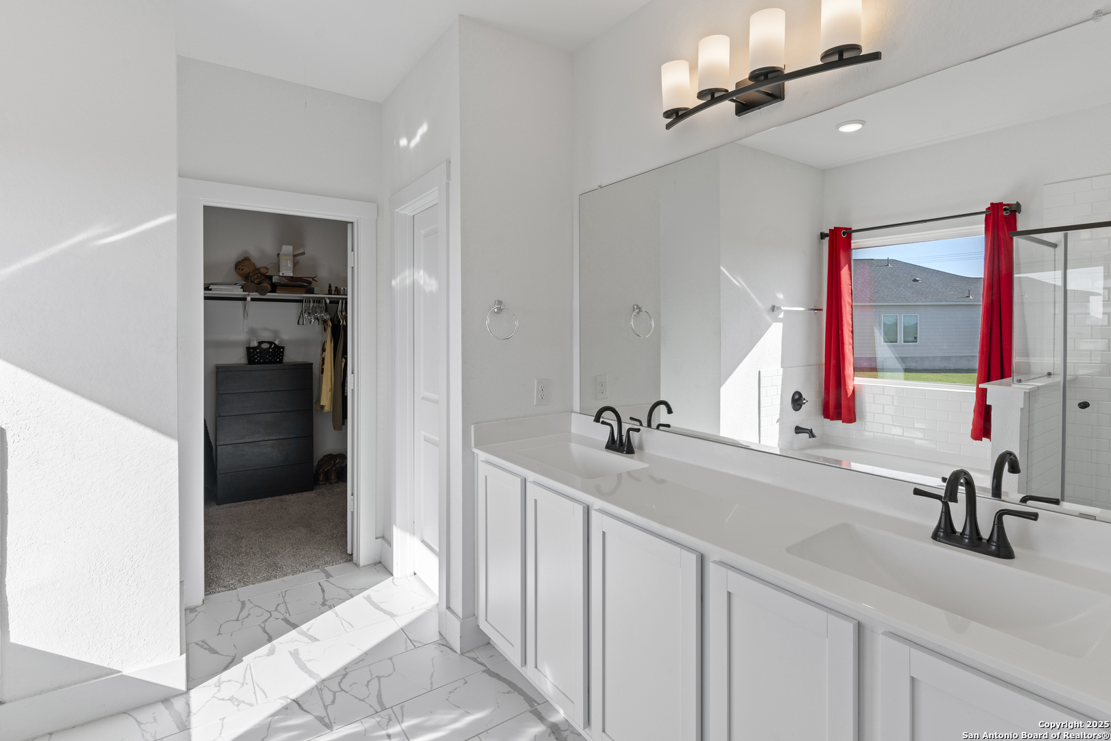 8823 Catnip Pass Elmendorf, TX 78112 - Photo 23 of 34 a en suite bathroom with a sink and a mirror