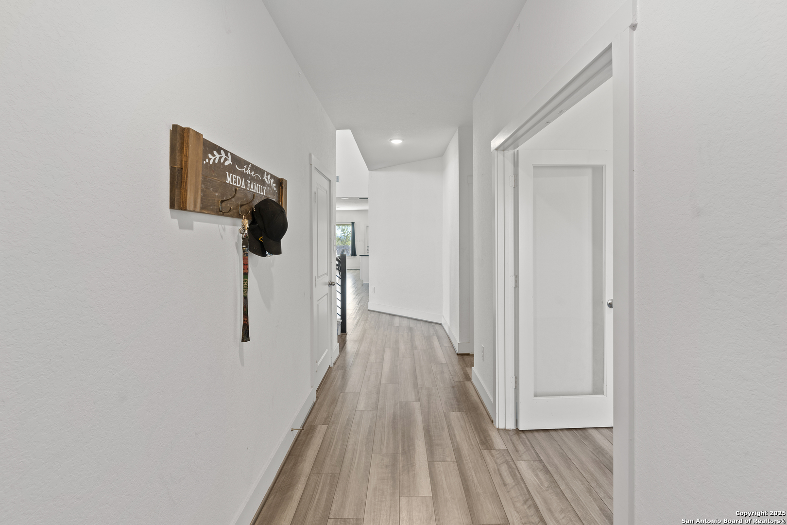 8823 Catnip Pass Elmendorf, TX 78112 - Photo 9 of 34 a view of a hallway with wooden floor and staircase