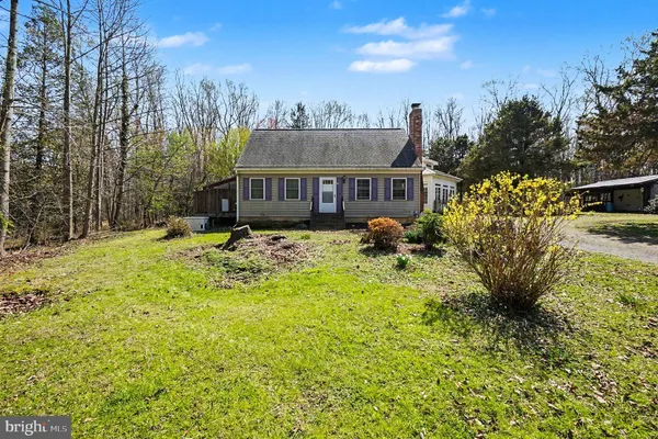a front view of a house with a yard and trees