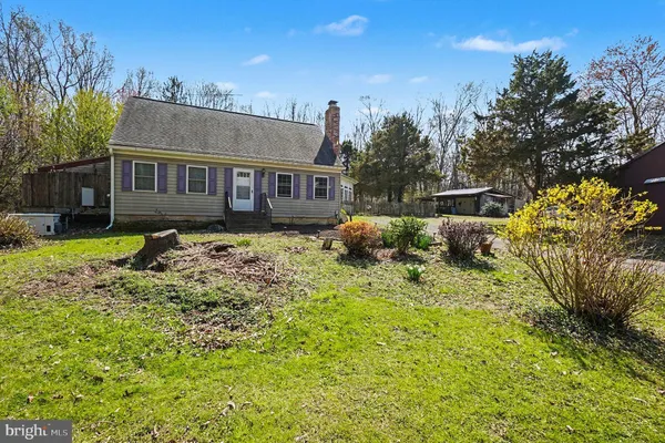 a front view of a house with a garden and trees