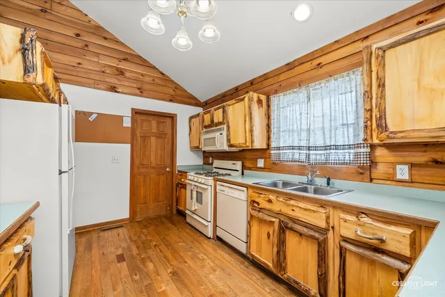 a kitchen with stainless steel appliances granite countertop a stove cabinets and wooden floor