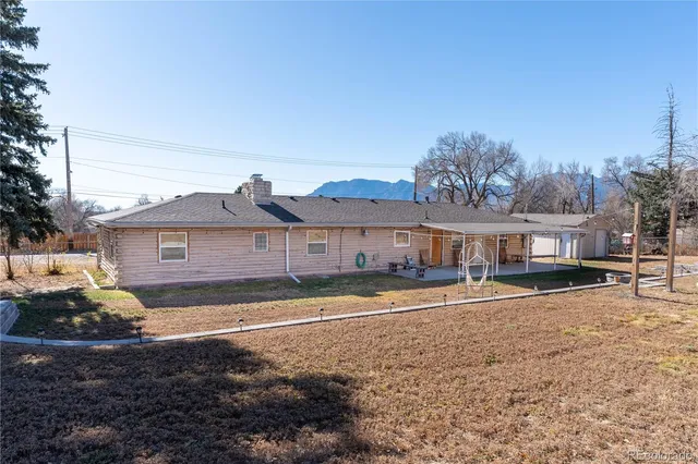 a view of a big house with a big yard and large tree