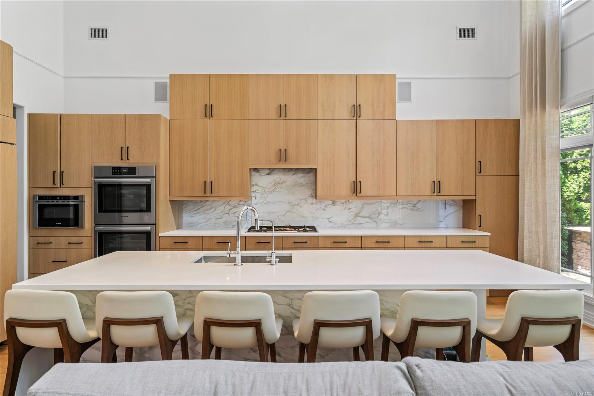 8 Holiday Pond Road Jericho, NY 11753 - Photo 12 of 43 Kitchen with a breakfast bar area, decorative backsplash, light countertops, and a high ceiling