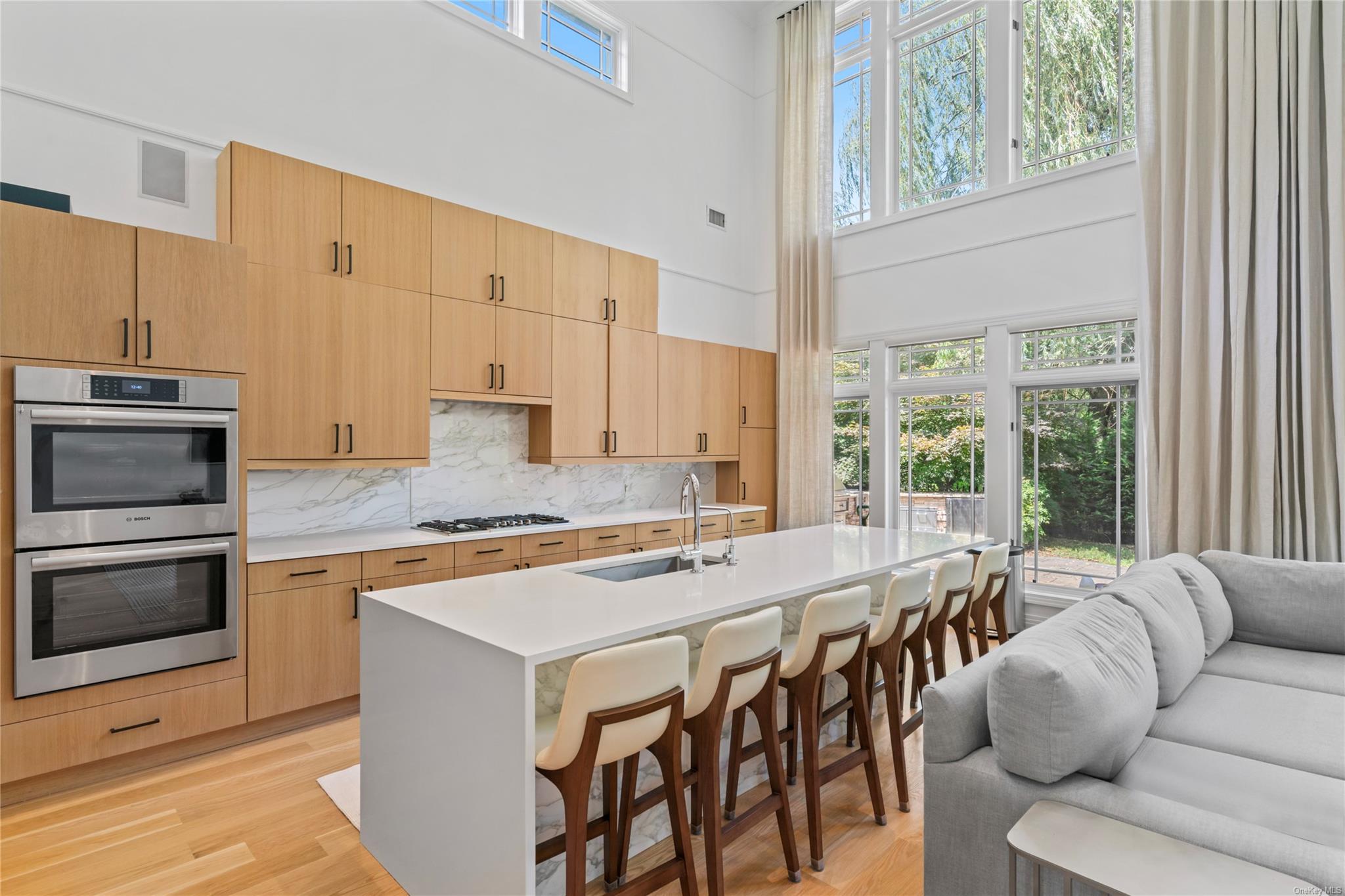 8 Holiday Pond Road Jericho, NY 11753 - Photo 13 of 43 Kitchen featuring appliances with stainless steel finishes, a high ceiling, light wood-style floors, light countertops, and a breakfast bar area