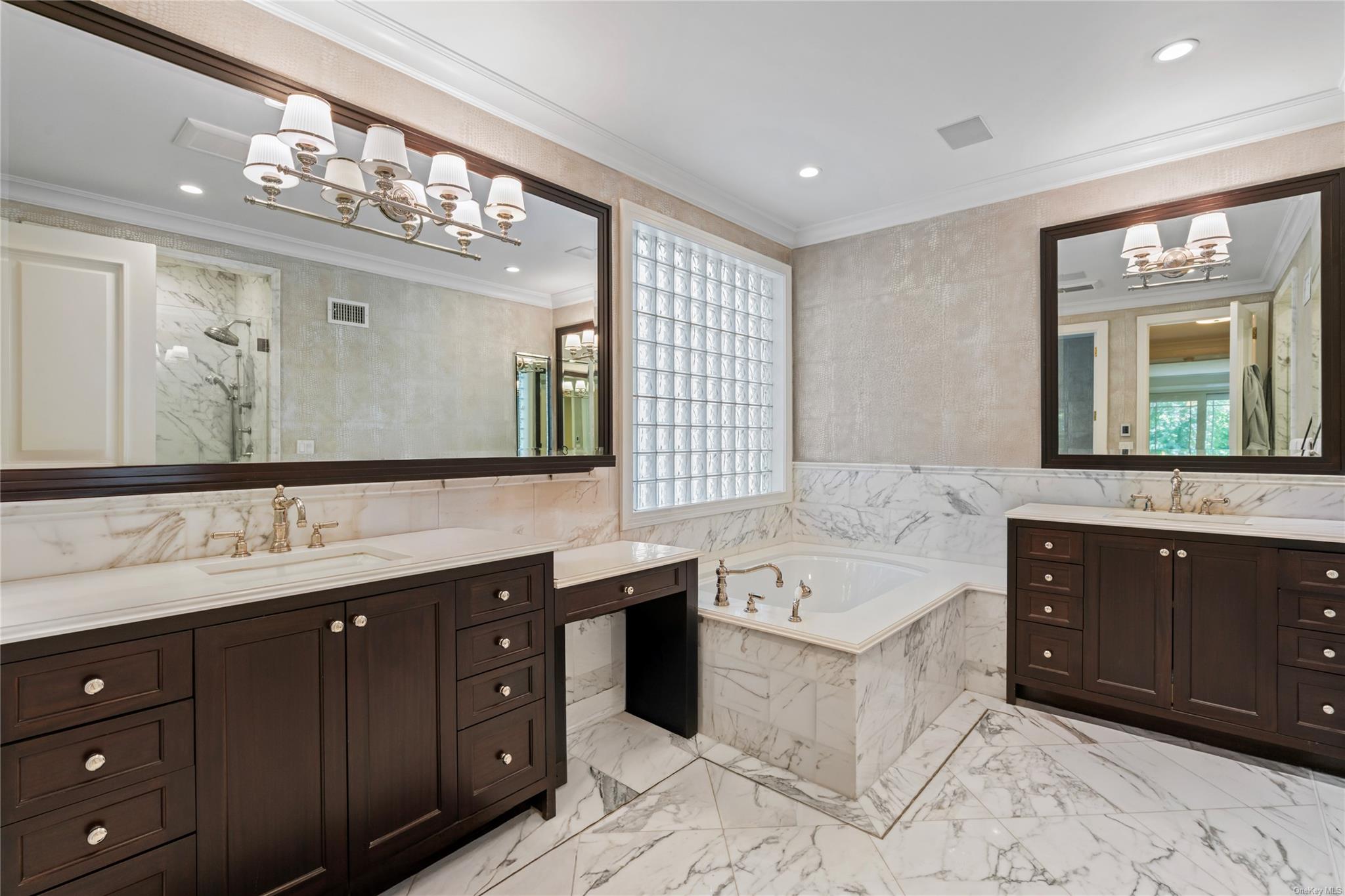 8 Holiday Pond Road Jericho, NY 11753 - Photo 22 of 43 Bathroom featuring a chandelier, a bath, two vanities, healthy amount of natural light, and tile walls