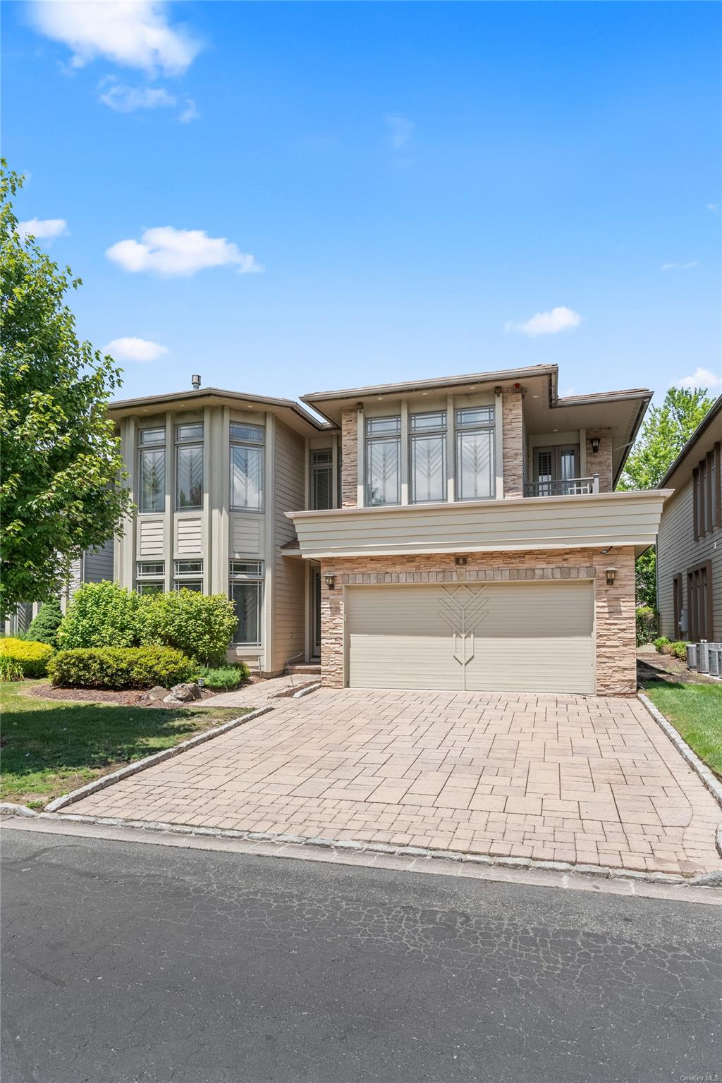 8 Holiday Pond Road Jericho, NY 11753 - Photo 3 of 43 View of front of property featuring decorative driveway, an attached garage, and stone siding