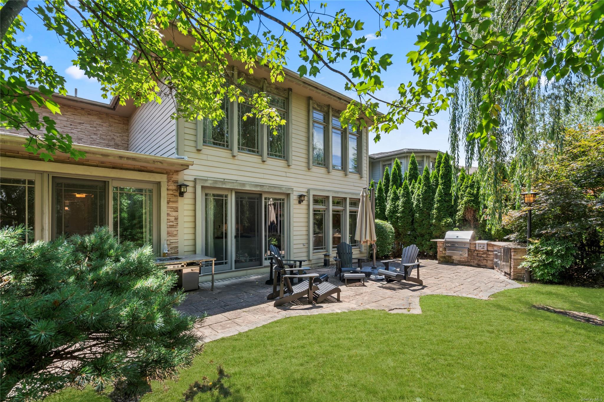 8 Holiday Pond Road Jericho, NY 11753 - Photo 35 of 43 Rear view of property with an outdoor kitchen, a lawn, a patio, and stone siding