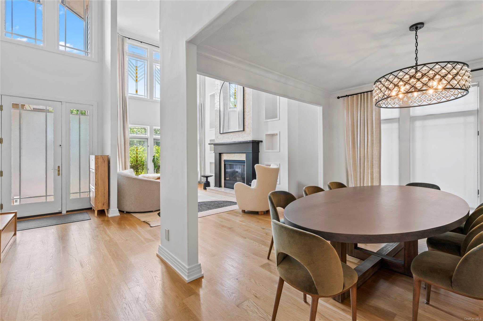 8 Holiday Pond Road Jericho, NY 11753 - Photo 7 of 43 Dining space featuring plenty of natural light, a premium fireplace, a chandelier, light wood finished floors, and ornamental molding