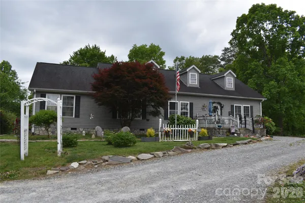 a front view of a house with a yard and trees