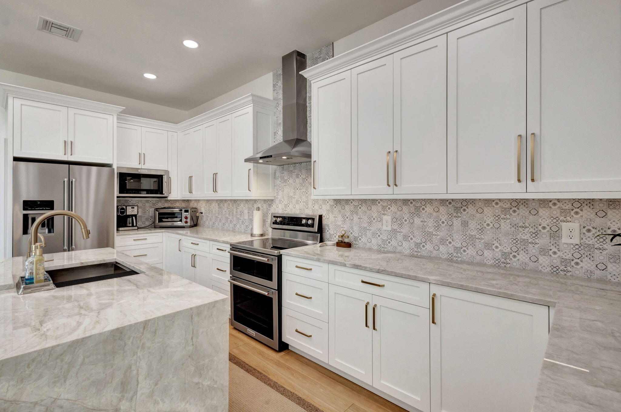 12952 Drayton Road North Palm Beach, FL 33408 - Photo 36 of 109 a kitchen with white cabinets and stainless steel appliances