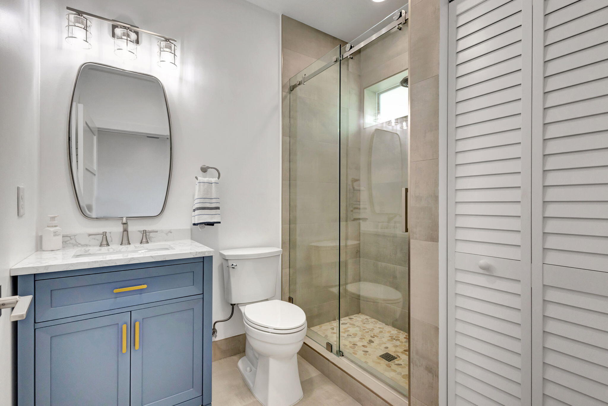 12952 Drayton Road North Palm Beach, FL 33408 - Photo 71 of 109 a bathroom with a toilet a sink a glass door a shower a mirror a vanity and window