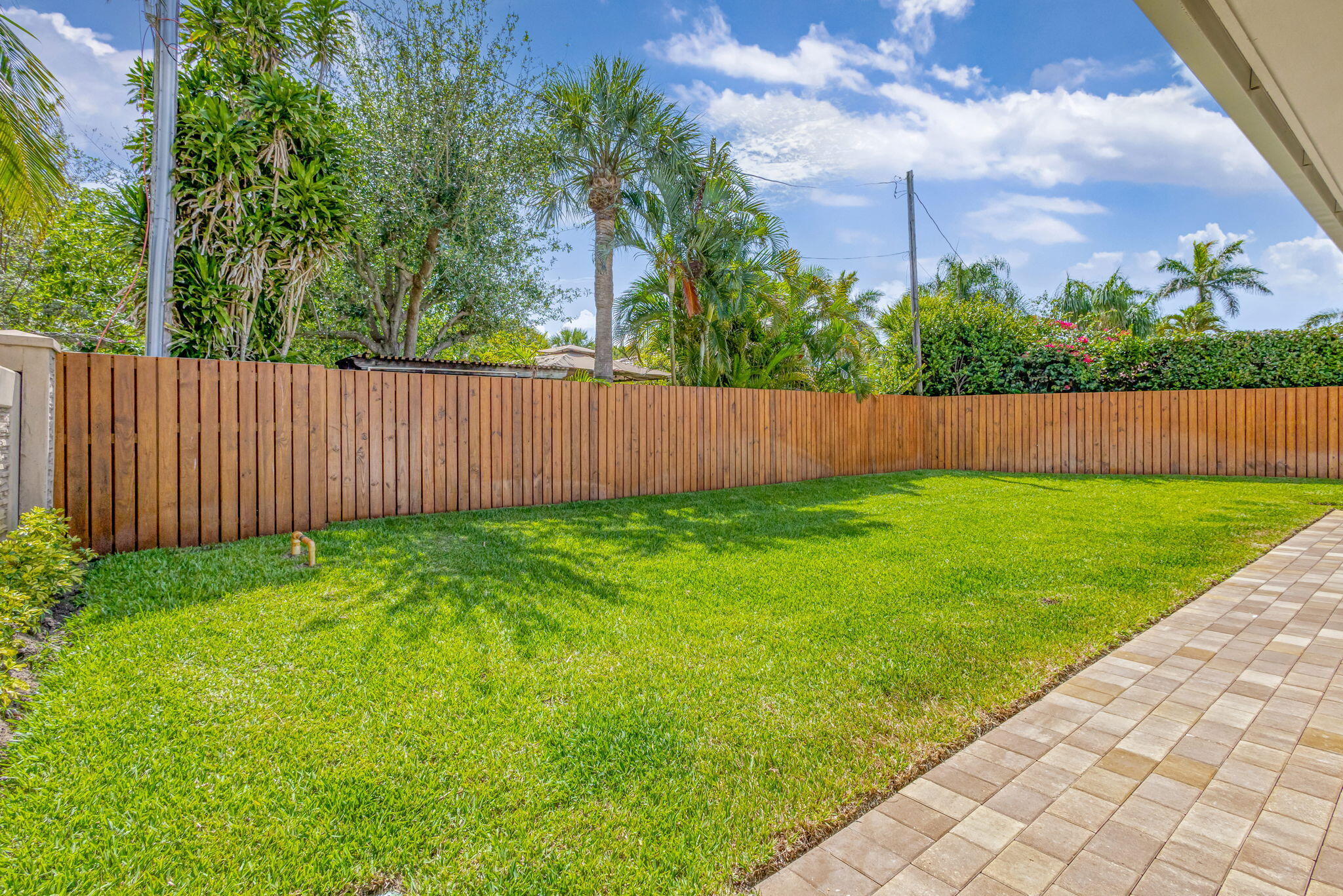 12952 Drayton Road North Palm Beach, FL 33408 - Photo 89 of 109 a view of a backyard with a garden and wooden fence