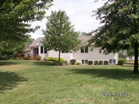 11884 Lerwick Road Caledonia, IL 61011 - Photo 2 of 11 a front view of a house with a garden and trees