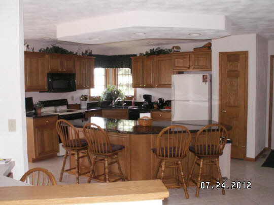 11884 Lerwick Road Caledonia, IL 61011 - Photo 4 of 11 a kitchen with stainless steel appliances kitchen island granite countertop a refrigerator and a stove top oven