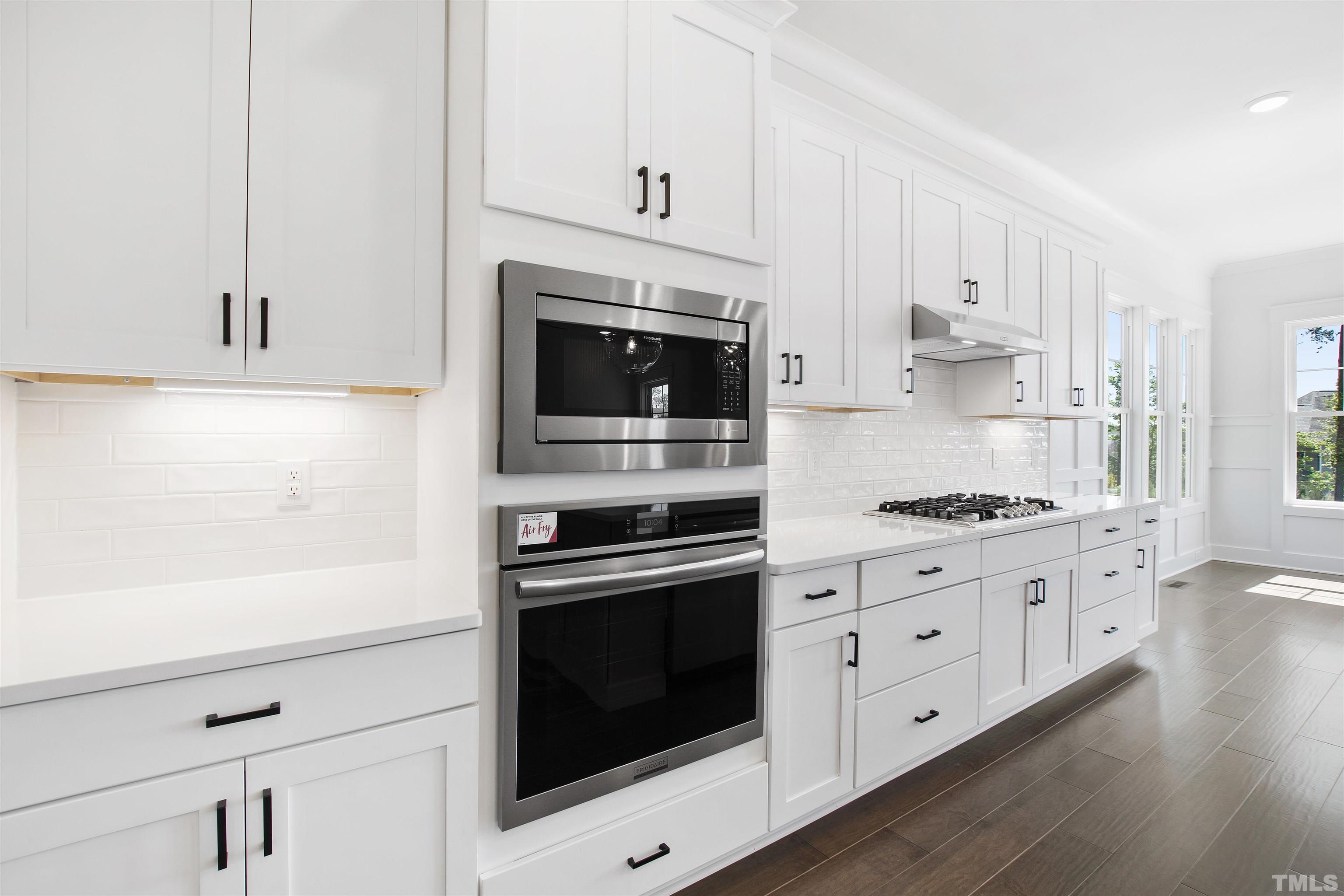 7512 Pinecrest Road Raleigh, NC 27613 - Photo 12 of 47 a kitchen with granite countertop white cabinets and white appliances