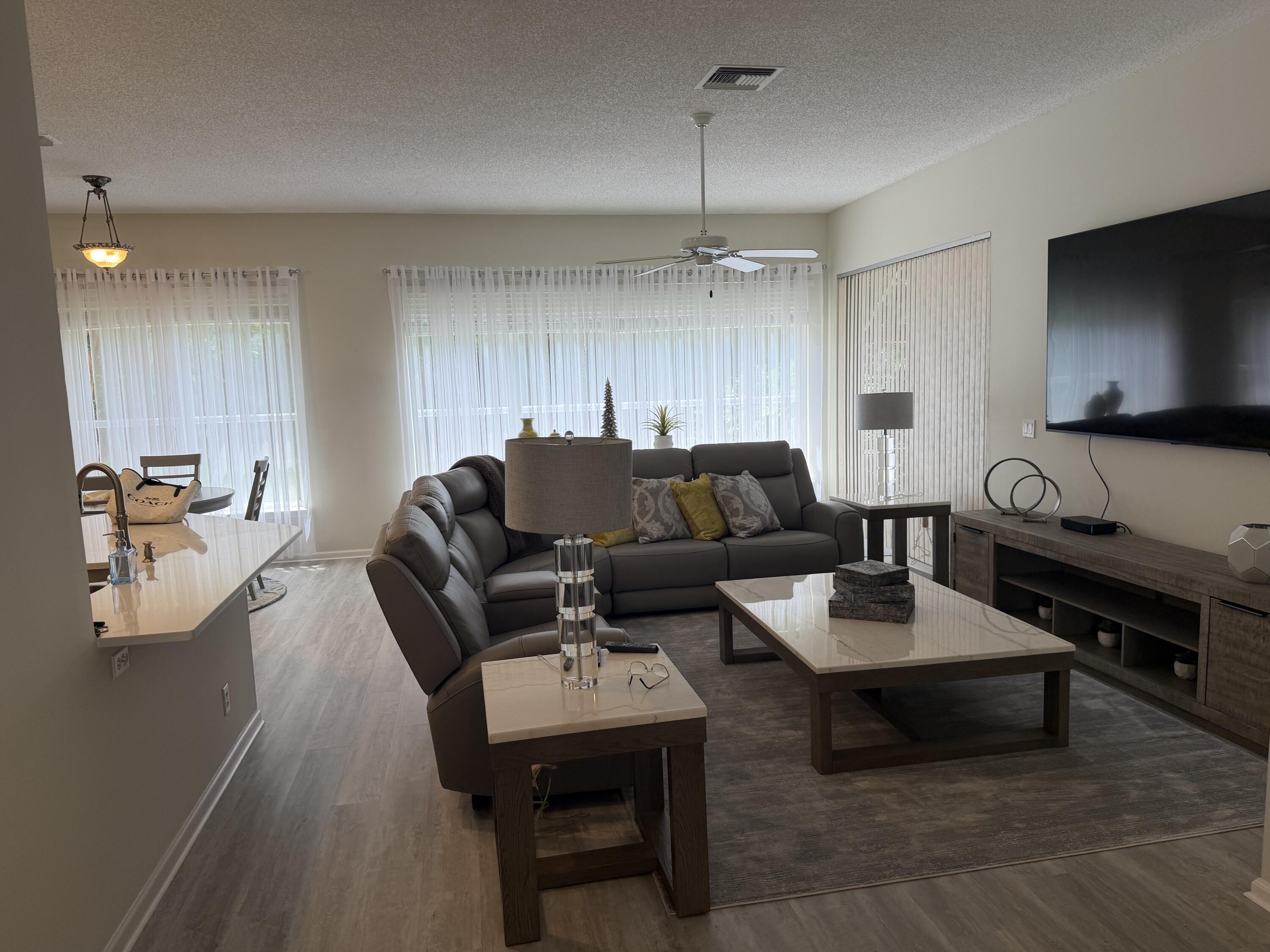 7936 Rockford Road Boynton Beach, FL 33472 - Photo 3 of 14 a living room with furniture a rug and a flat screen tv