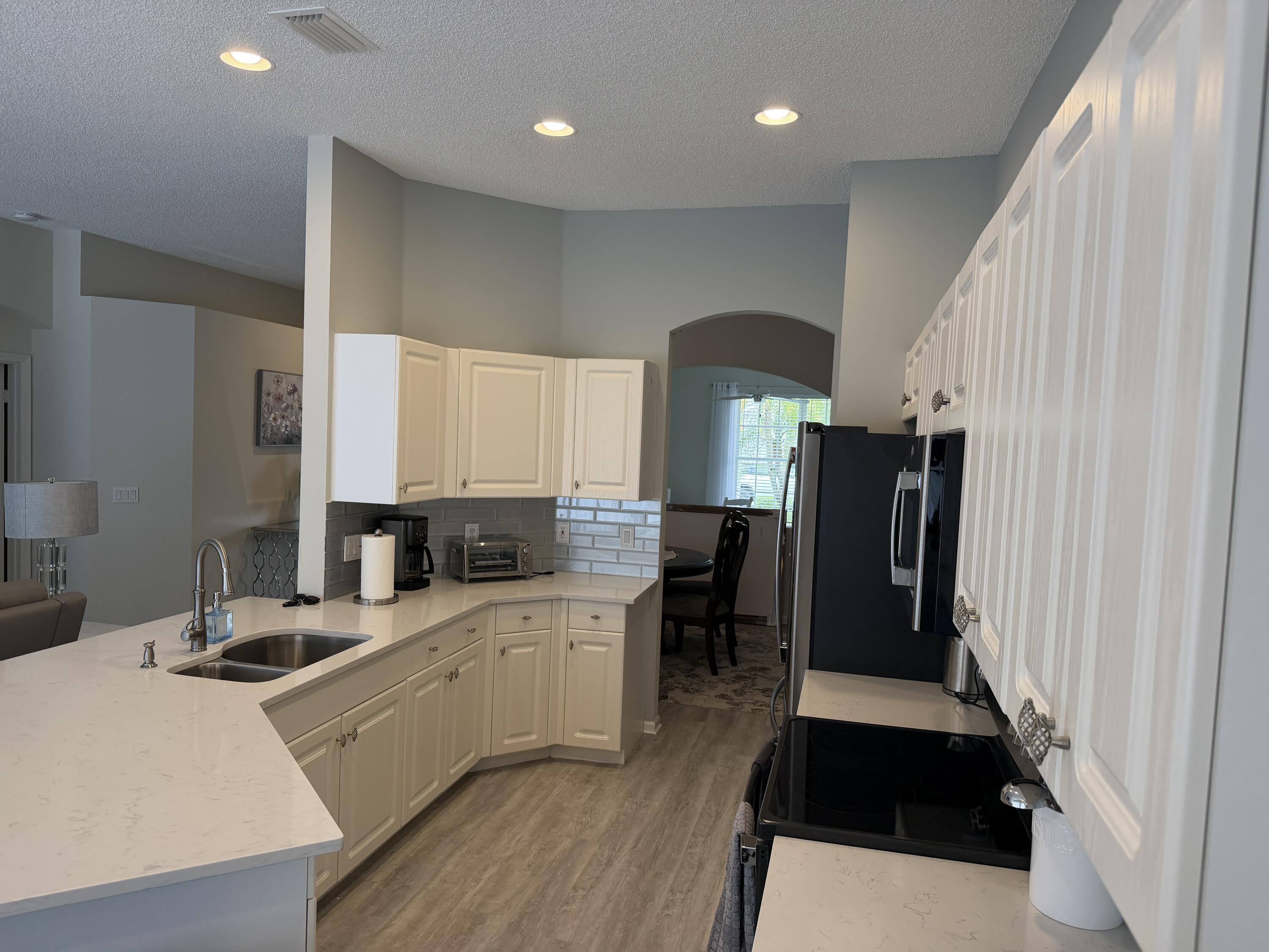 7936 Rockford Road Boynton Beach, FL 33472 - Photo 4 of 14 a large white kitchen with sink and refrigerator