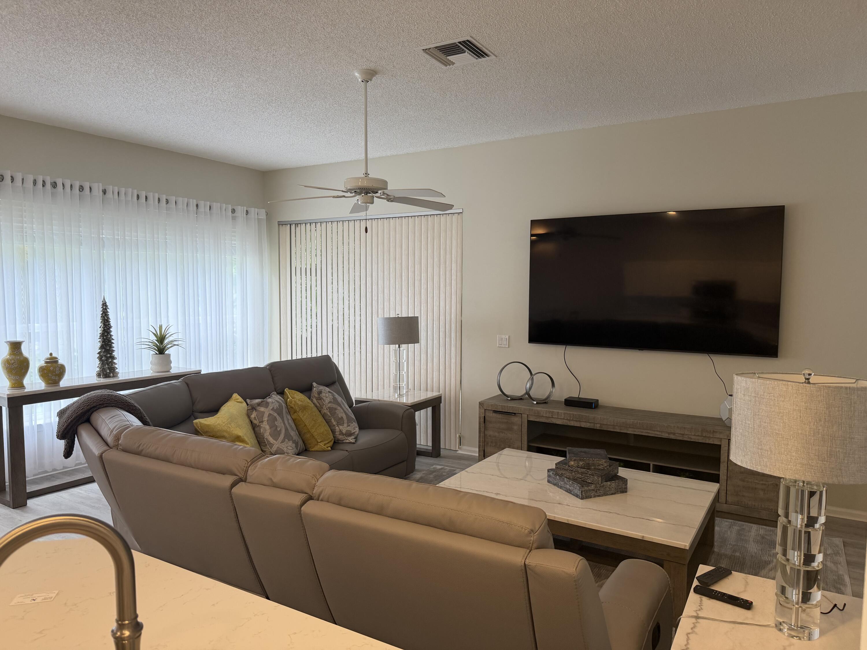 7936 Rockford Road Boynton Beach, FL 33472 - Photo 5 of 14 a living room with furniture and a flat screen tv