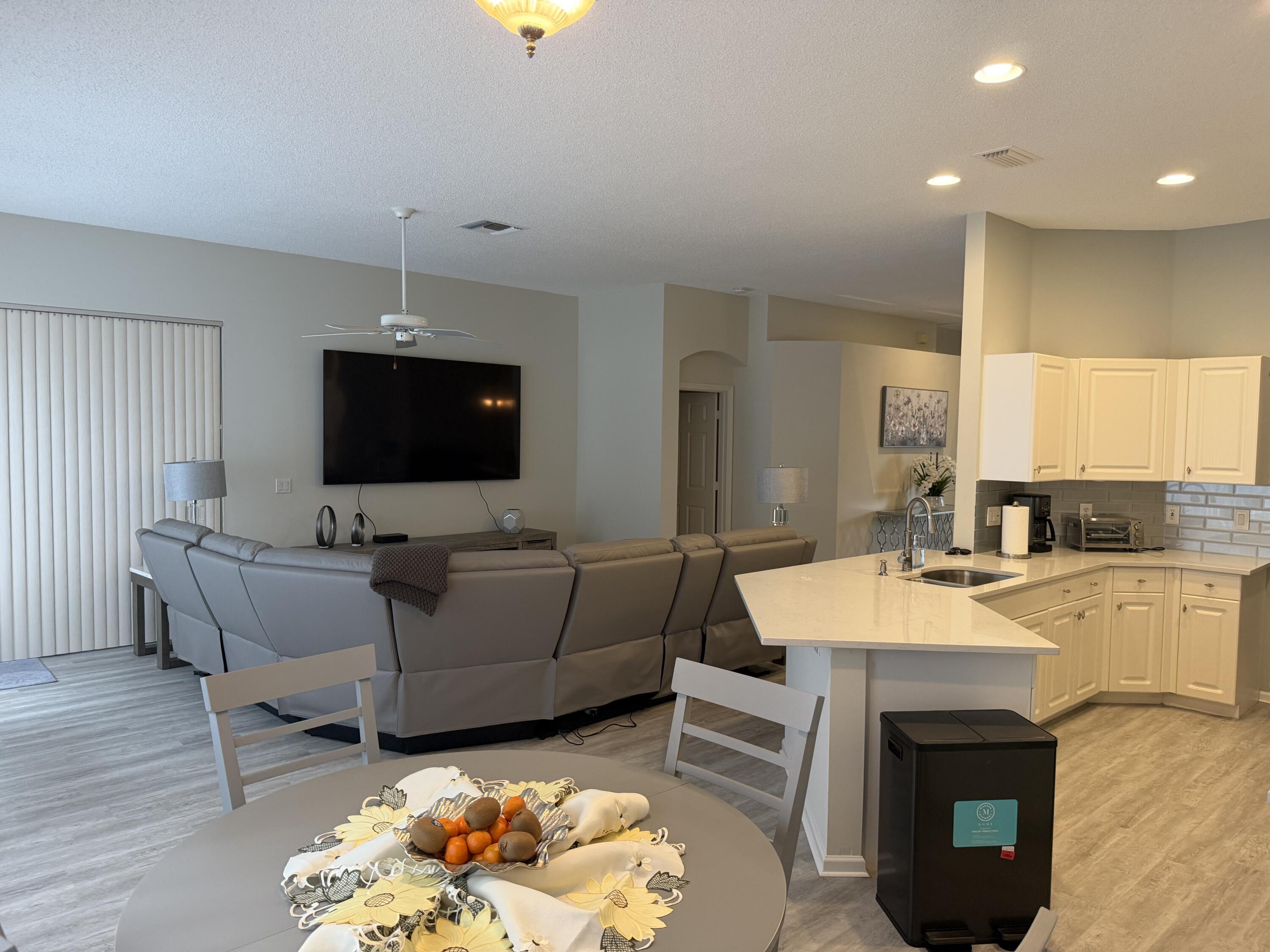 7936 Rockford Road Boynton Beach, FL 33472 - Photo 6 of 14 a living room with furniture a fireplace and a flat screen tv