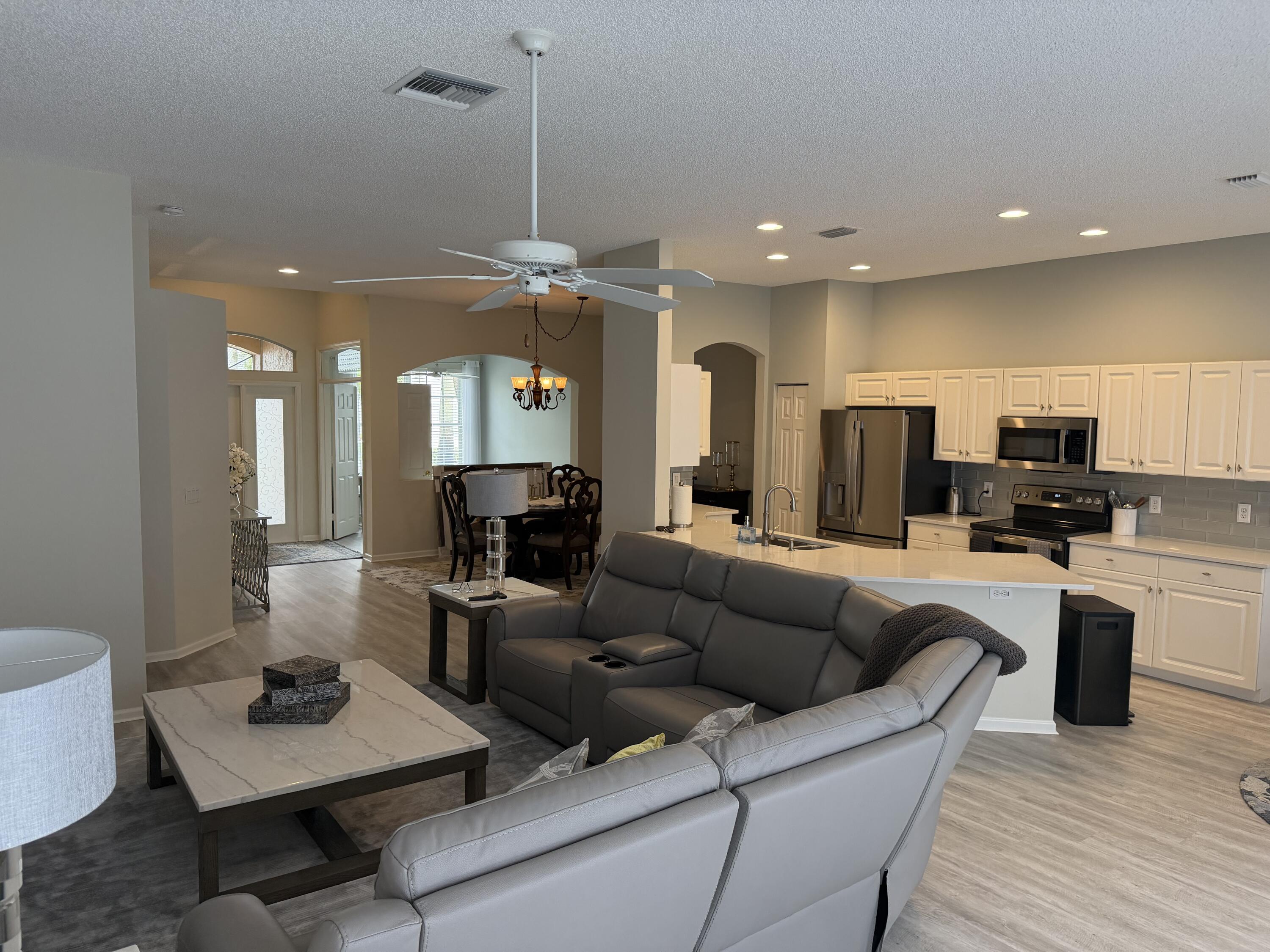 7936 Rockford Road Boynton Beach, FL 33472 - Photo 7 of 14 a living room with furniture kitchen view and a wooden floor