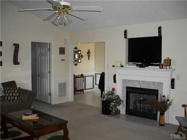 57 Rodney Court Willow Spring, NC 27592 - Photo 3 of 16 a living room with furniture a flat screen tv and a fireplace