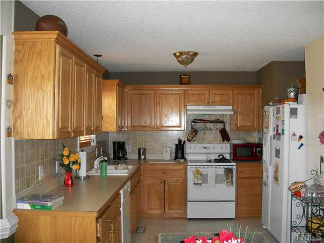 57 Rodney Court Willow Spring, NC 27592 - Photo 8 of 16 a kitchen with stainless steel appliances granite countertop a sink stove and refrigerator