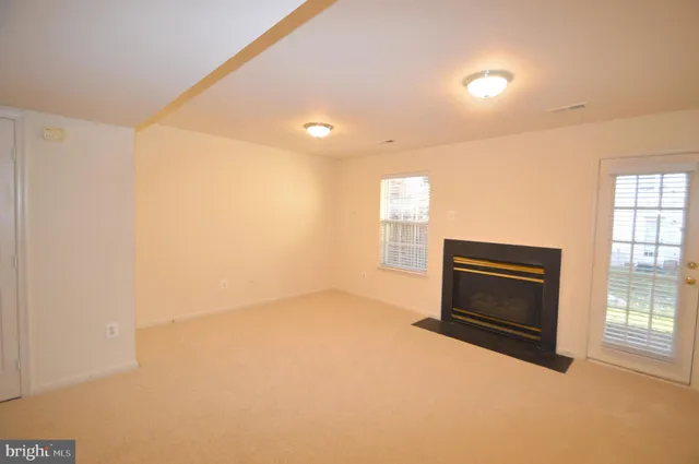 a view of empty room with a fireplace and windows