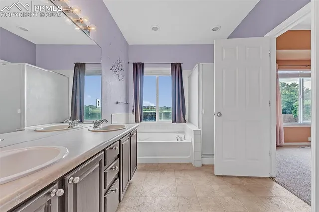 a bathroom with a granite countertop sink and a bathtub