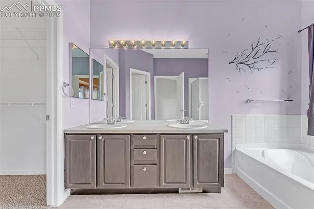 a spacious bathroom with a granite countertop sink a mirror and bathtub