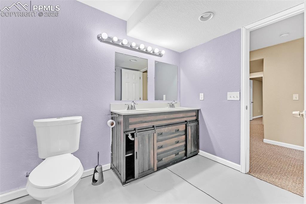 9403 St.George Road Peyton, CO 80831 - Photo 35 of 39 a bathroom with a toilet a sink and mirror