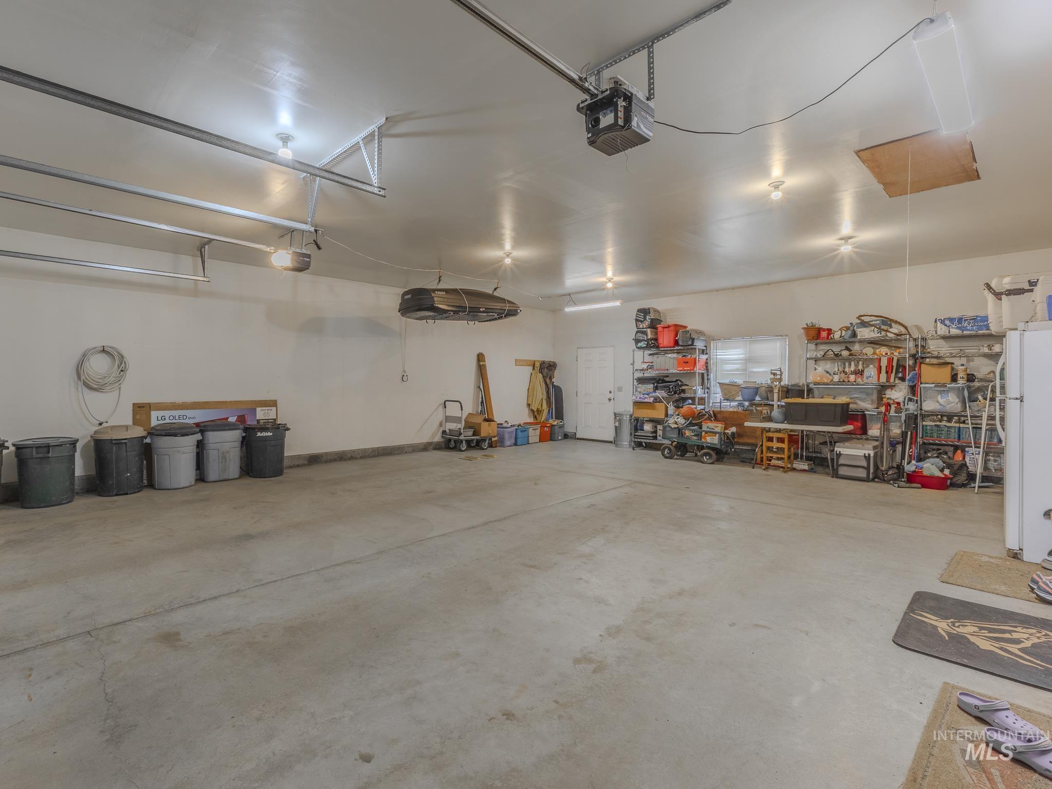 202 Fish Hatchery Road Grangeville, ID 83530 - Photo 29 of 50 Garage with freestanding refrigerator, a garage door opener, and a workshop area