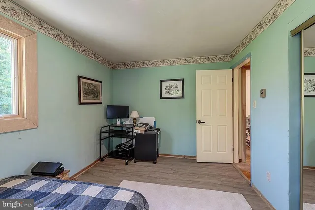 a view of a workspace with furniture and a window