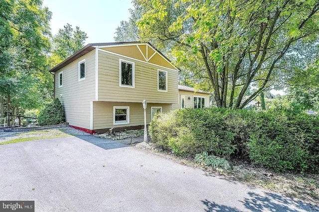 a view of a house with backyard and trees