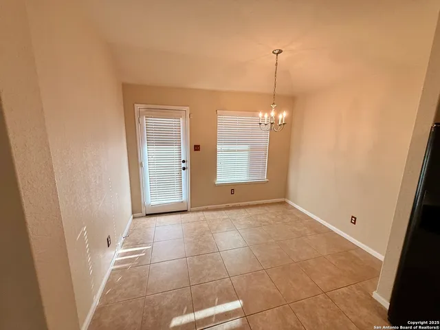 an empty room with wooden floor and fan