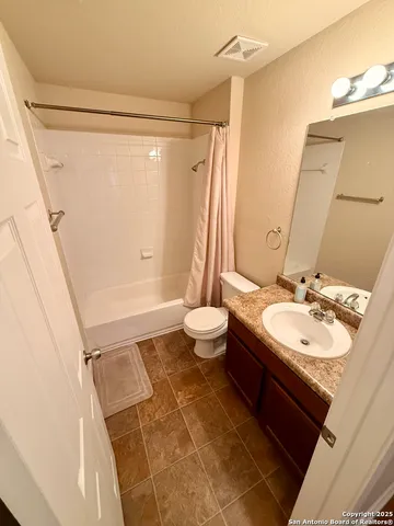 a kitchen with granite countertop a refrigerator and a stove top oven