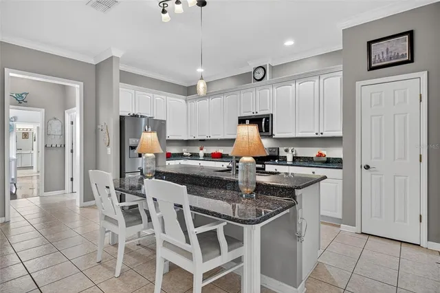 a kitchen with granite countertop a sink appliances and cabinets