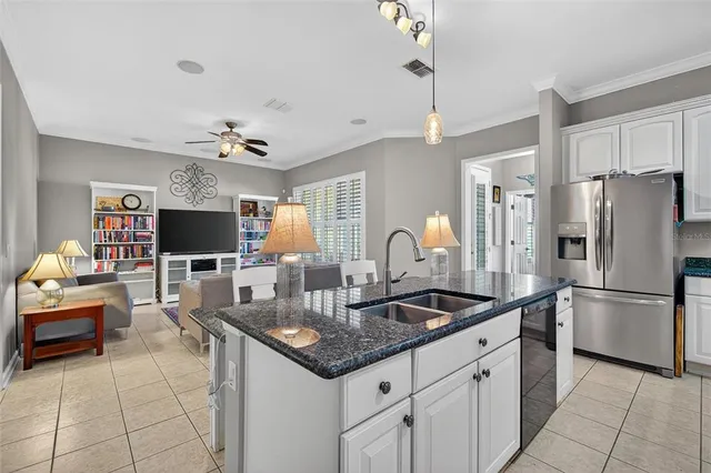 a kitchen with stainless steel appliances a stove a refrigerator a sink a stove a dining table and chairs