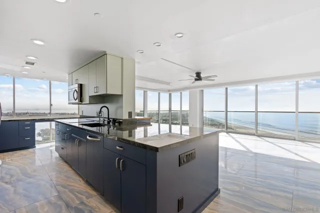 a large kitchen with granite countertop a sink and a stove top oven with wooden floor