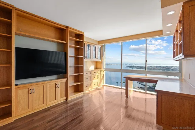 a living room with a flat screen tv and a floor to ceiling window